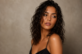 Brünette Frau mit mittellangen, definierten Wet-Look-Locken nach moderner Dauerwelle beim Coiffeur HairXperience in Wetzikon
